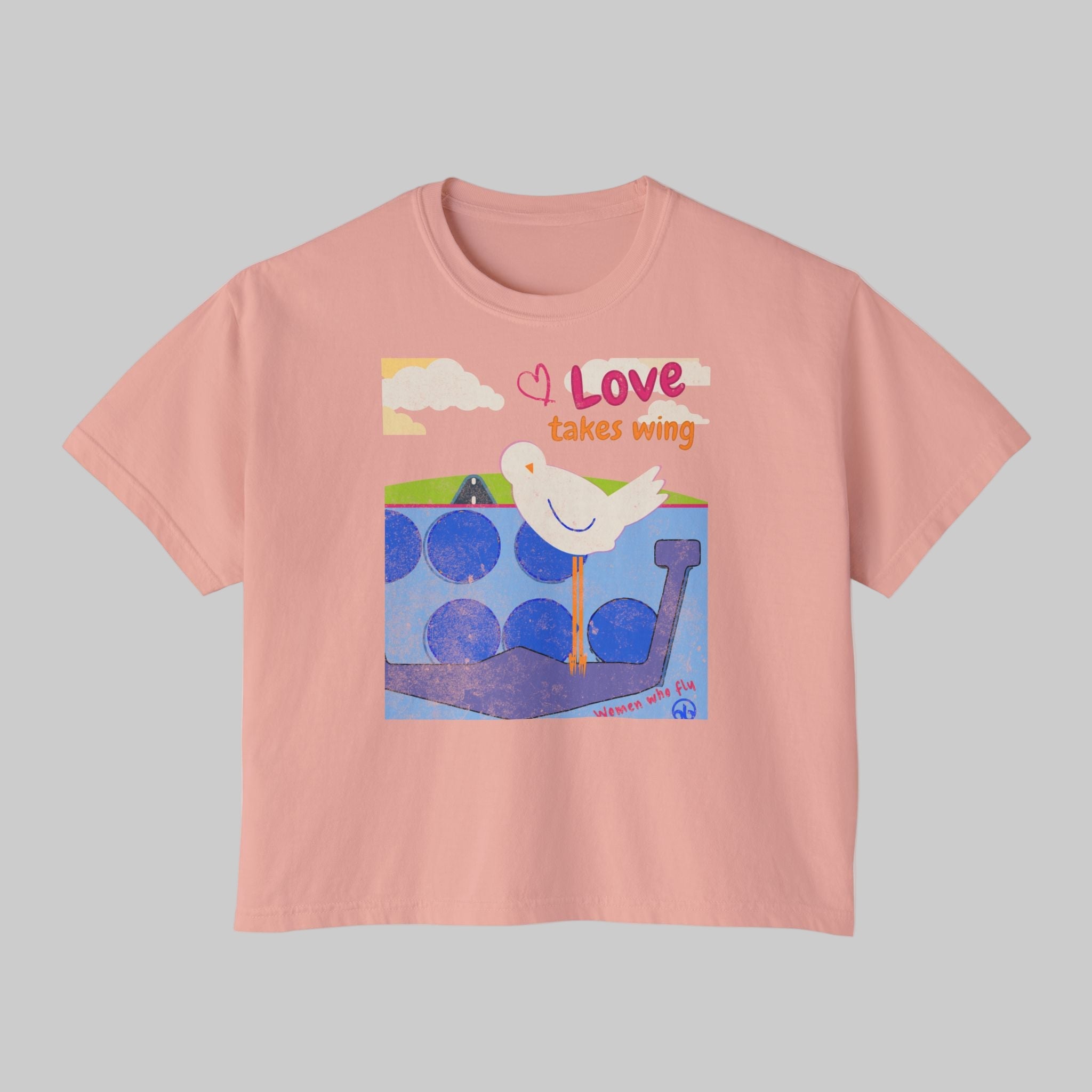 Pink t-shirt with a graphic of a dove and text 'Love takes wing' on a white background