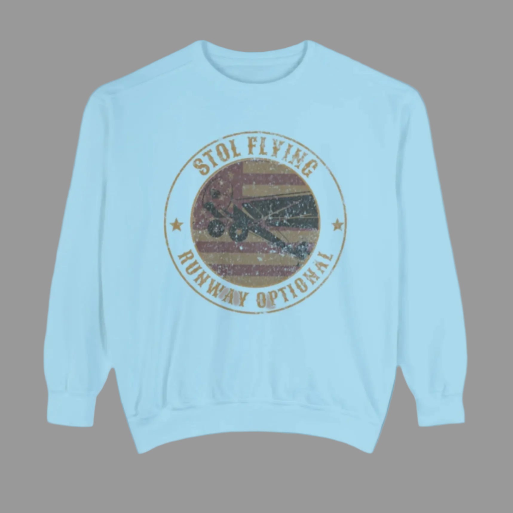 A white sweatshirt with a graphic of a Piper Super Cub and the text 'STOL FLYING - RUNWAY OPTIONAL' in a circular design.