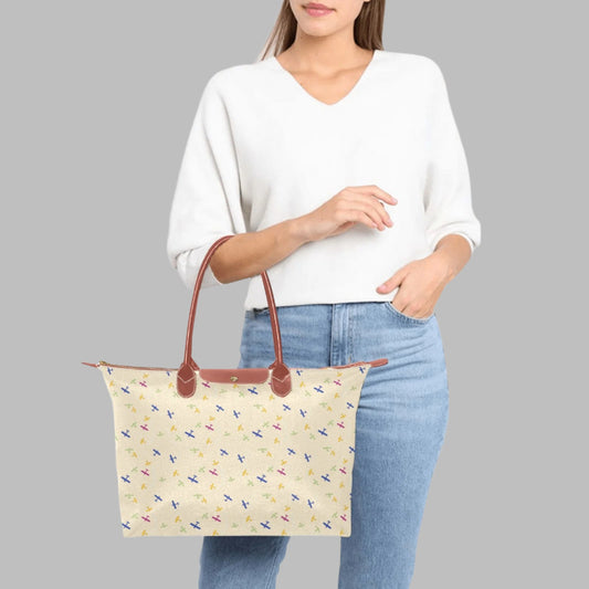 cream color handbag with rolled straps and airplane design